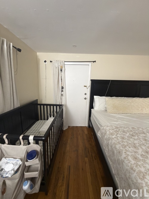 A bedroom with a crib and a bed.