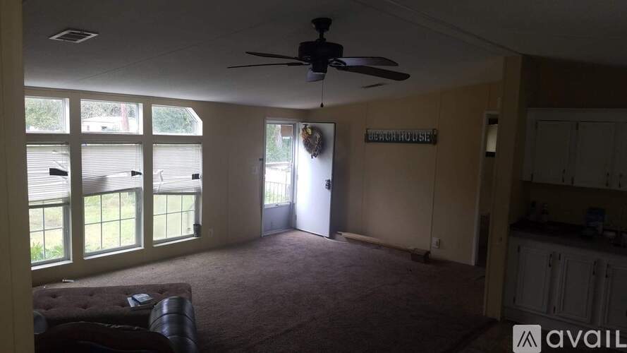 A living room with a couch and a ceiling fan.