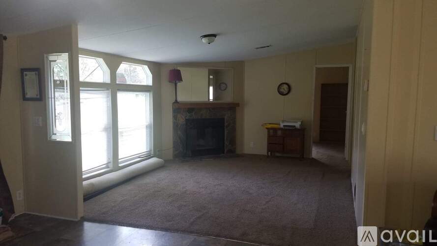 A living room with a fireplace and a large window.