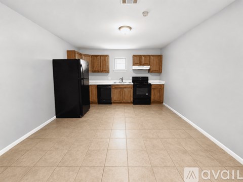 A kitchen with black appliances and wooden cabinets.