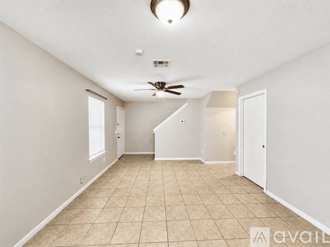 A spacious room with a fan and tiled floor.