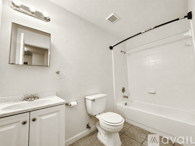 A white bathroom with a toilet, sink, and bathtub.