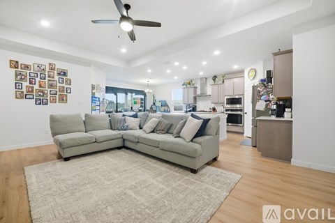 A living room with a grey couch and a rug in the middle.