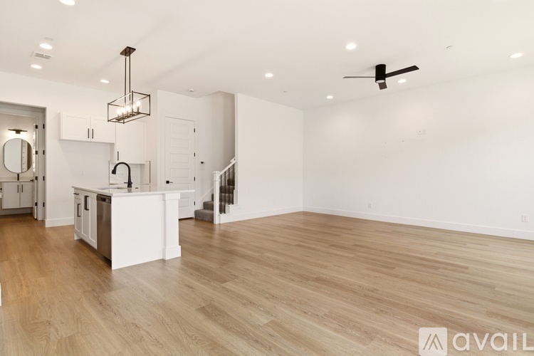 A spacious kitchen with white cabinets and a wooden floor.