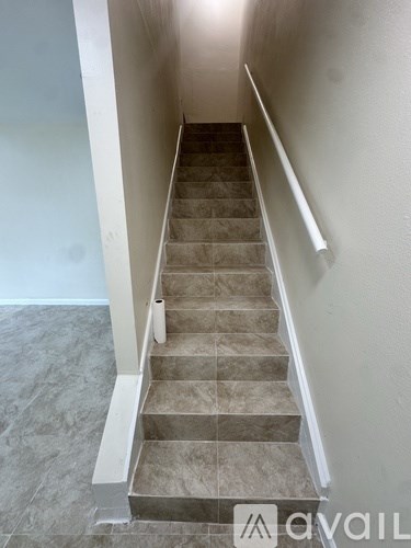 A staircase with beige carpeted steps and white handrails.