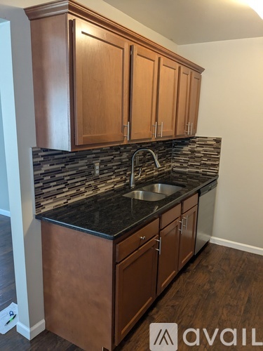 A kitchen with wooden cabinets and a black granite countertop.