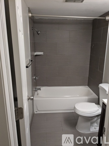 A bathroom with a toilet, tub, and shower.