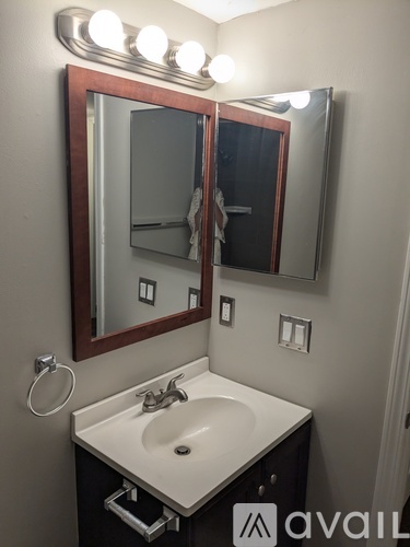 A bathroom with a sink, mirror, and lights.