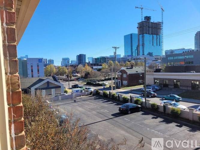 A parking lot with cars and a building under construction in the background.
