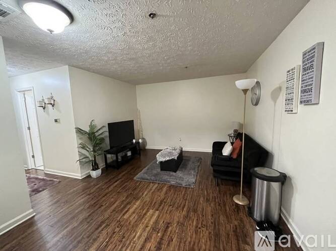 A living room with a black couch and a television.