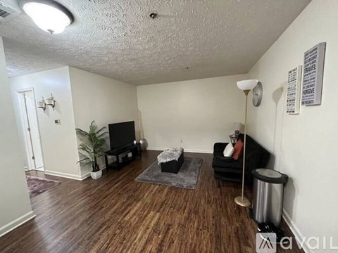 A living room with a black couch and a television.