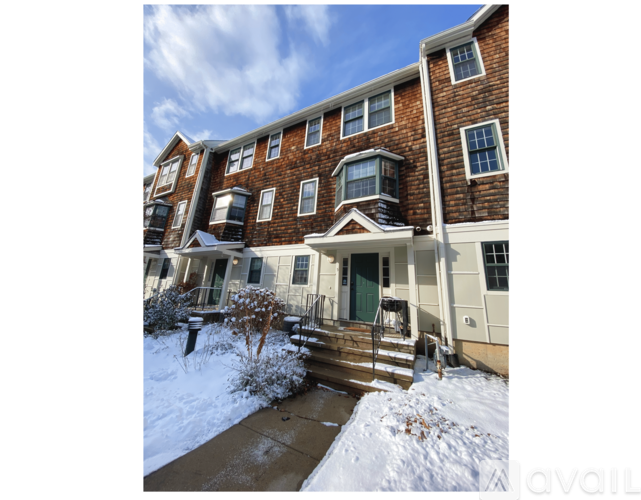 A brick apartment building with a snow-covered ground.