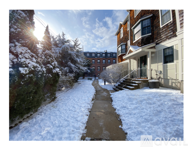 A snow-covered pathway leads to a building with a balcony.