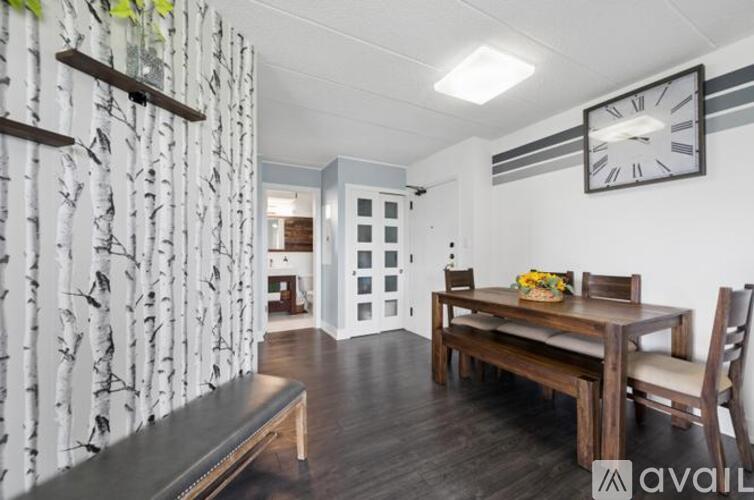 A dining room with a wooden table and chairs.