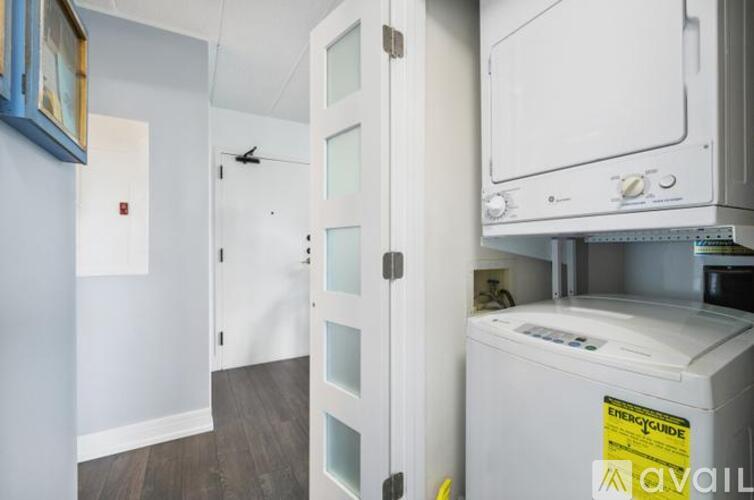 A white dishwasher is in a kitchen with a white door.