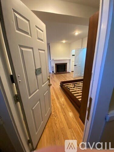 A hallway with a white door and a wooden floor.