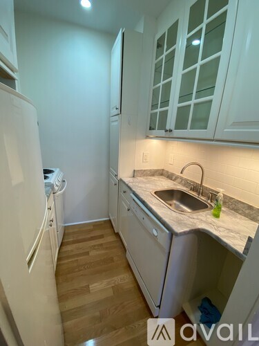 A kitchen with white cabinets and a white refrigerator.