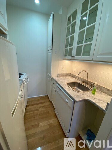 A kitchen with white cabinets and a white refrigerator.