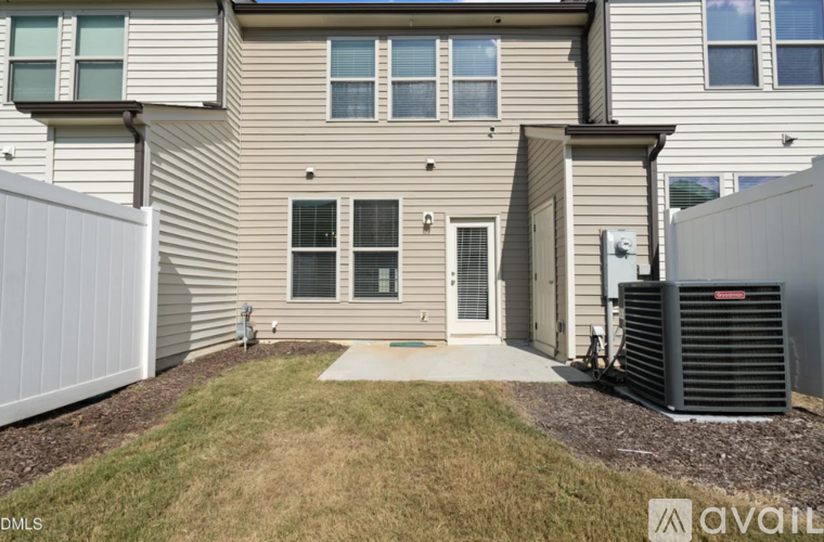 A house with a grey siding exterior and a white fence.