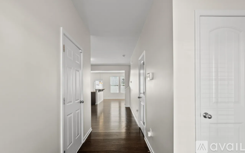 A long hallway with white walls and wood floors.