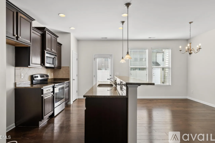 A modern kitchen with dark wood cabinets and a central island.