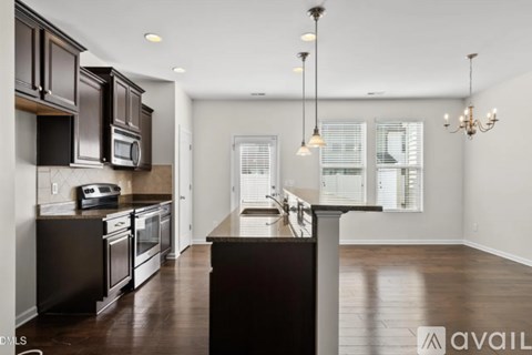 A modern kitchen with dark wood cabinets and a central island.