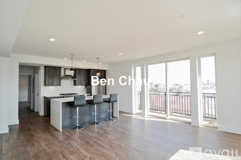 A modern kitchen with a bar area and a view of the city.