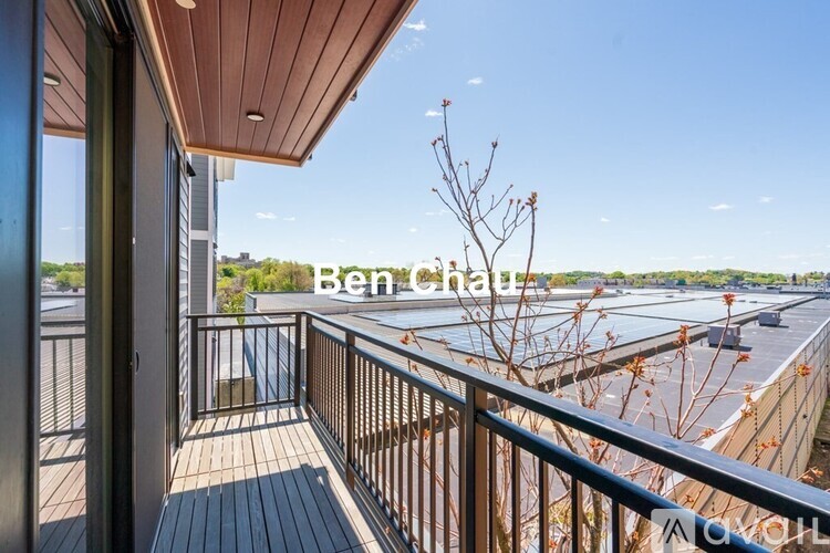 A balcony with a railing and a tree in the distance.