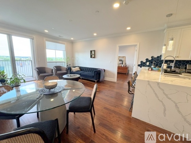 A modern living room with a glass dining table and chairs.