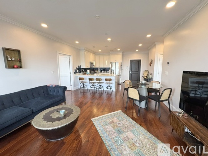 A living room with a black sofa and a coffee table.