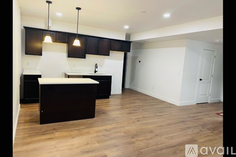 A kitchen with dark brown cabinets and a white countertop.
