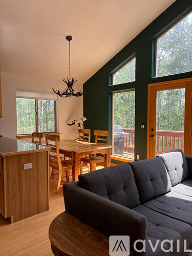 A living room with a grey couch and wooden furniture.