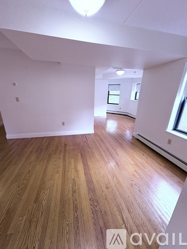 A room with wooden flooring and white walls.