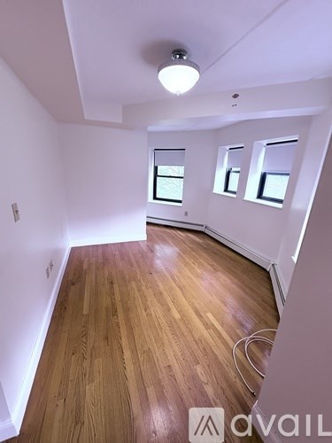 A room with wooden flooring and white walls.
