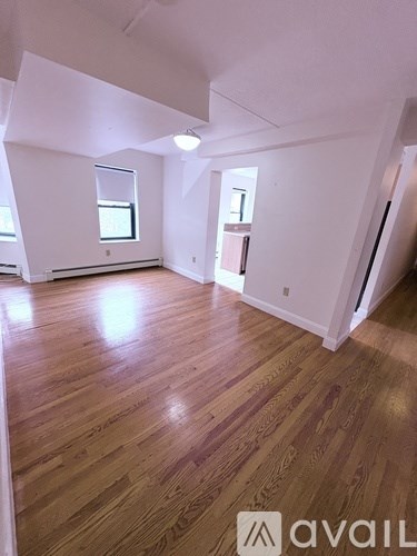 A room with wooden flooring and white walls.