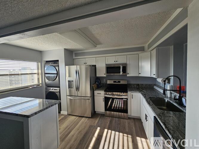 A kitchen with a refrigerator, oven, and microwave.