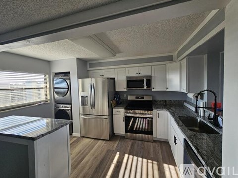 A kitchen with a refrigerator, oven, and microwave.