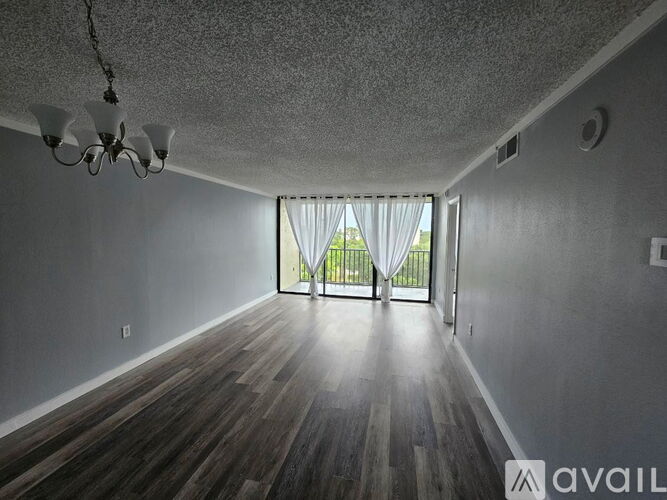 A room with wooden floors and a chandelier.