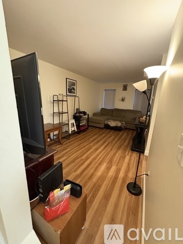 A living room with a television, a couch, and a lamp.