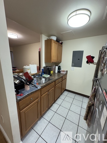 A kitchen with wooden cabinets and a tile floor.