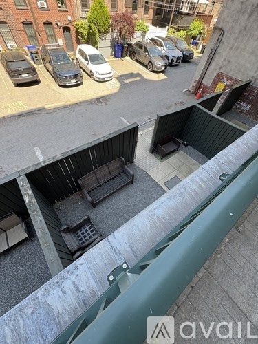 A parking lot with cars and a building with a balcony.