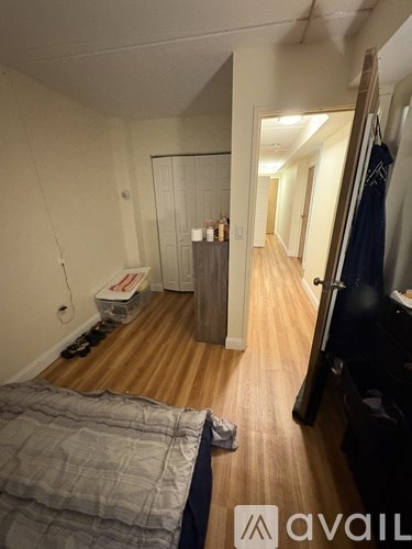 A bedroom with a bed on the left and a wardrobe on the right.