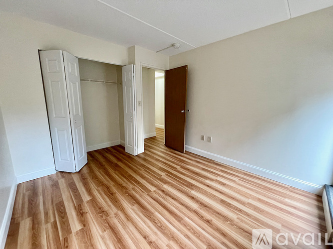 A room with wooden flooring and a white wall.