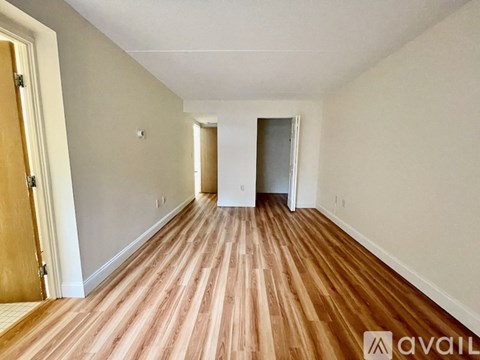 A room with wooden flooring and white walls.
