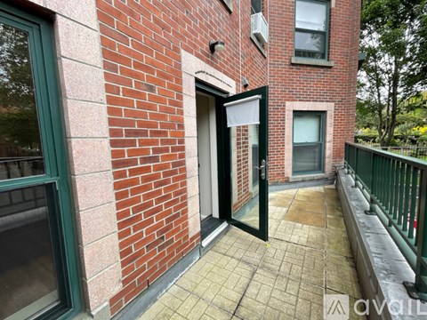 A brick building with a balcony and a door.