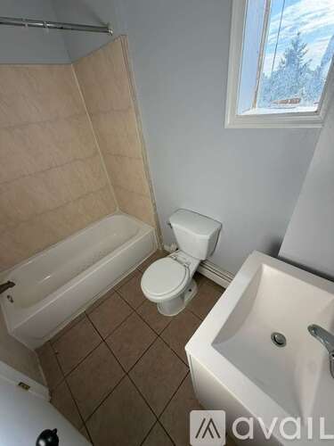 A bathroom with a toilet, sink, and bathtub.
