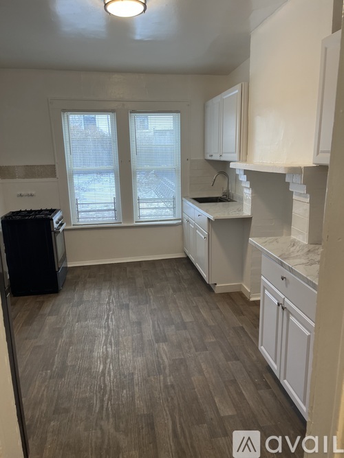 A kitchen with white cabinets and a black dishwasher.