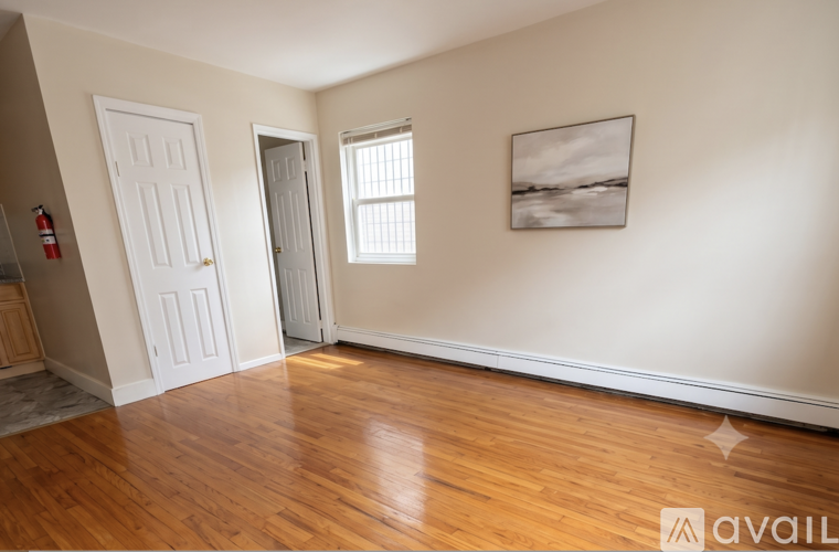 A room with wooden floors and a painting on the wall.