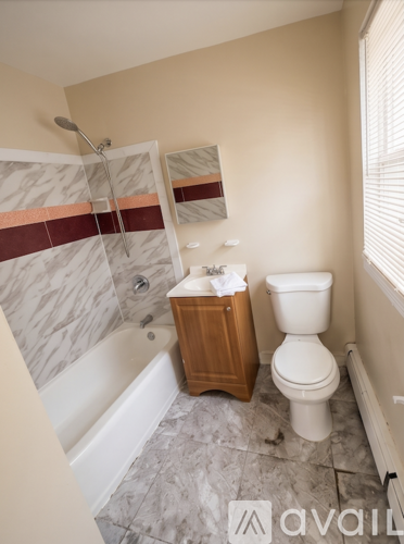 A bathroom with a toilet, a wooden cabinet, and a bathtub.