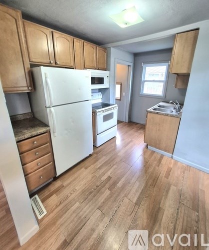 A kitchen with wooden cabinets and a white refrigerator.